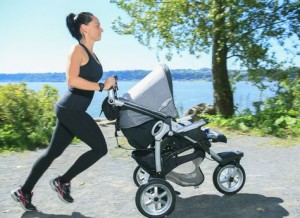 A Young mother jogging with a baby buggy